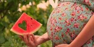görögdinnye szelet a terhes nő kezében